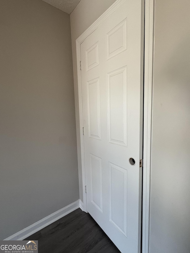 unfurnished bedroom with dark wood-style floors and baseboards