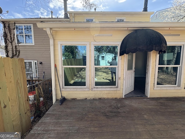 doorway to property with fence and a wooden deck