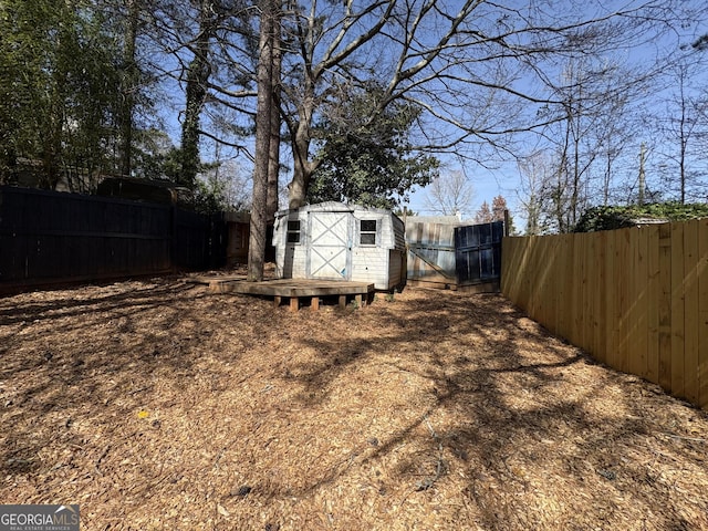 view of yard with an outdoor structure, a fenced backyard, and a storage shed