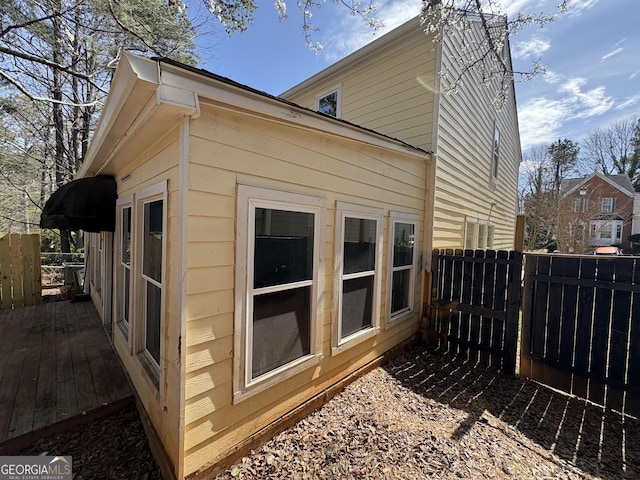 view of side of property with a deck and fence