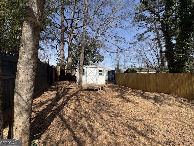 view of yard featuring an outbuilding, a storage shed, and a fenced backyard