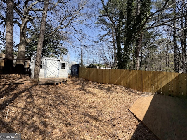 view of yard with a shed, an outdoor structure, and fence