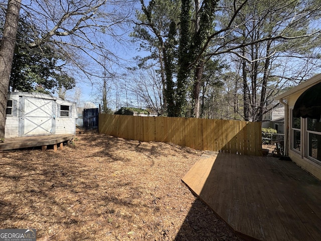 view of yard featuring a storage shed, an outdoor structure, and fence