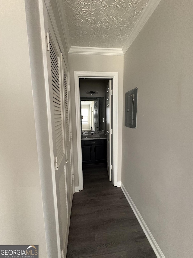 hallway with baseboards, ornamental molding, electric panel, dark wood-style floors, and a textured ceiling