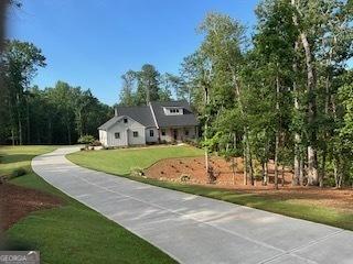 view of community with concrete driveway and a yard