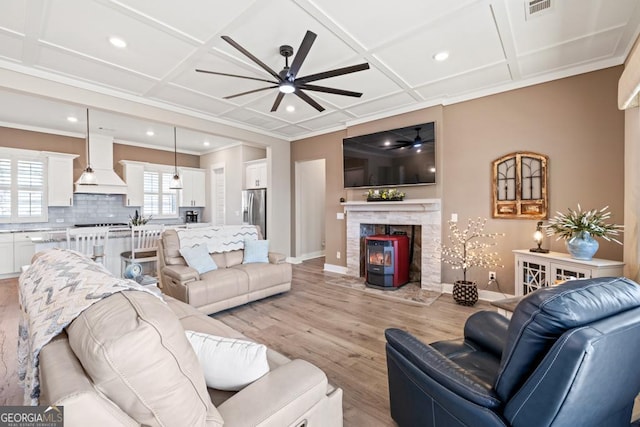 living area featuring a ceiling fan, light wood-style floors, baseboards, and coffered ceiling