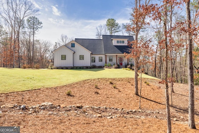 view of front of home featuring board and batten siding, a front lawn, and a shingled roof