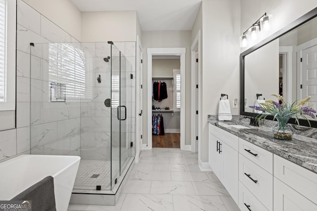 bathroom featuring a freestanding bath, marble finish floor, a stall shower, and vanity