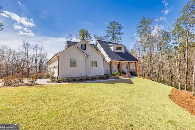 modern farmhouse with an attached garage, board and batten siding, covered porch, and a front lawn