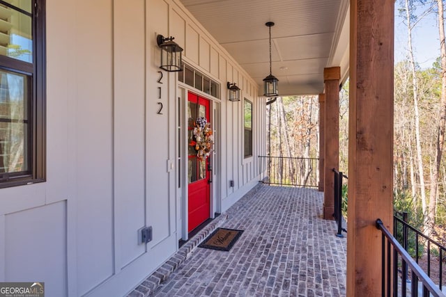 property entrance with covered porch and board and batten siding