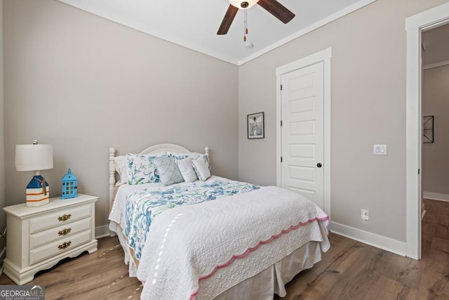 bedroom featuring ornamental molding, a ceiling fan, baseboards, and wood finished floors