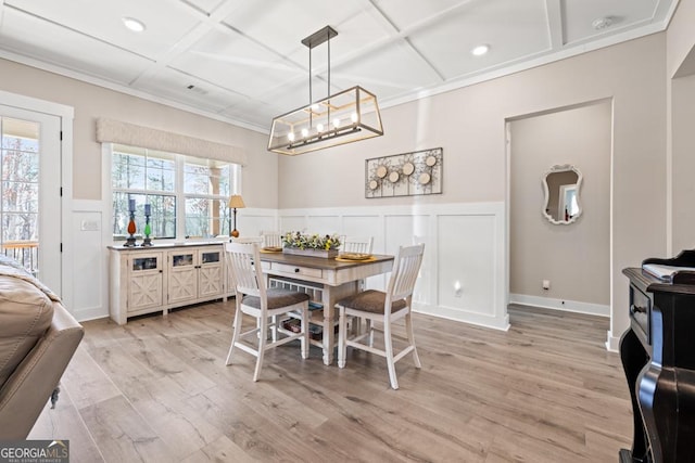 dining room featuring visible vents, crown molding, a wainscoted wall, light wood-type flooring, and coffered ceiling