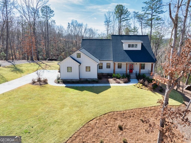 modern farmhouse featuring driveway, board and batten siding, roof with shingles, and a front lawn