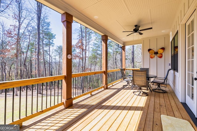 deck with outdoor dining area and ceiling fan