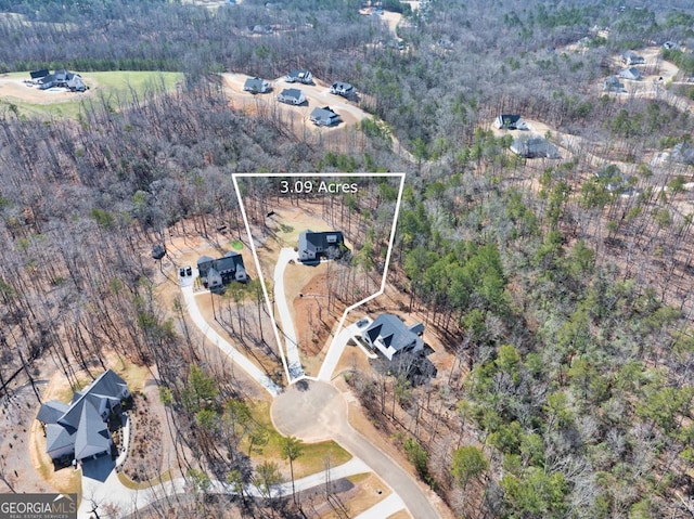 drone / aerial view featuring a wooded view