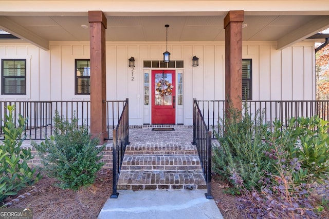 view of exterior entry featuring a porch and board and batten siding