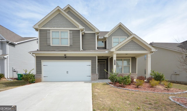 craftsman house with brick siding, an attached garage, and driveway