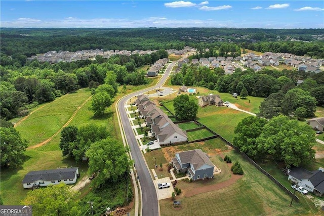 birds eye view of property featuring a residential view and a wooded view