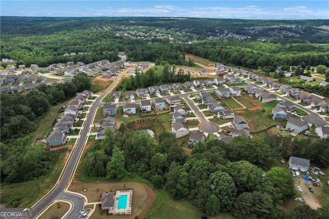 drone / aerial view featuring a residential view and a wooded view