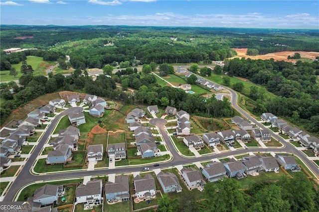 birds eye view of property with a view of trees and a residential view