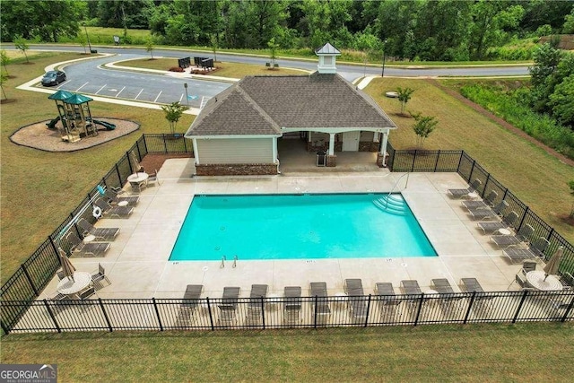 pool featuring an outbuilding, a patio, fence, an exterior structure, and a yard