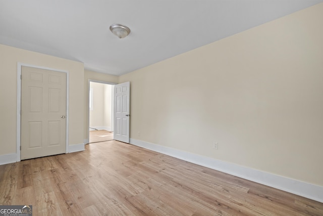 empty room featuring baseboards and light wood-style floors