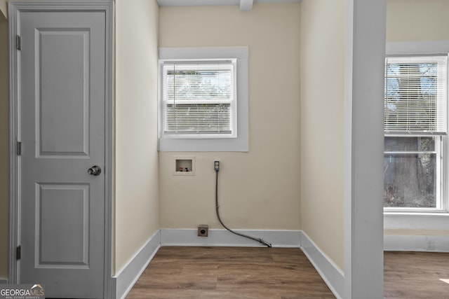 clothes washing area featuring baseboards, wood finished floors, and hookup for a washing machine