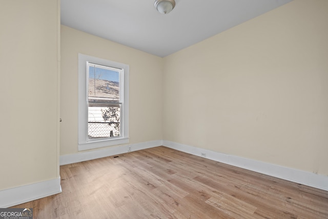 spare room featuring light wood finished floors and baseboards