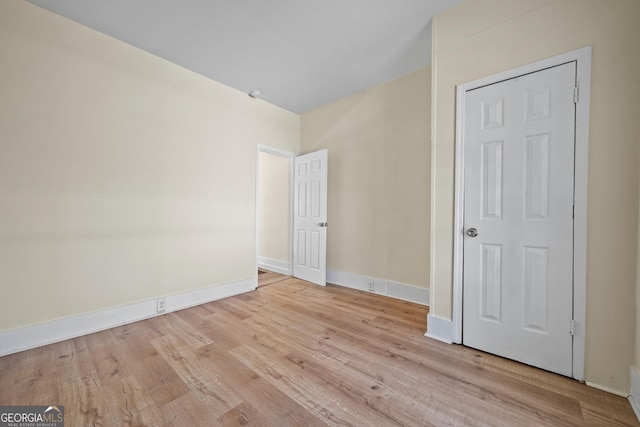 unfurnished bedroom featuring wood finished floors and baseboards