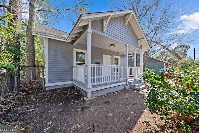 bungalow featuring a porch and fence