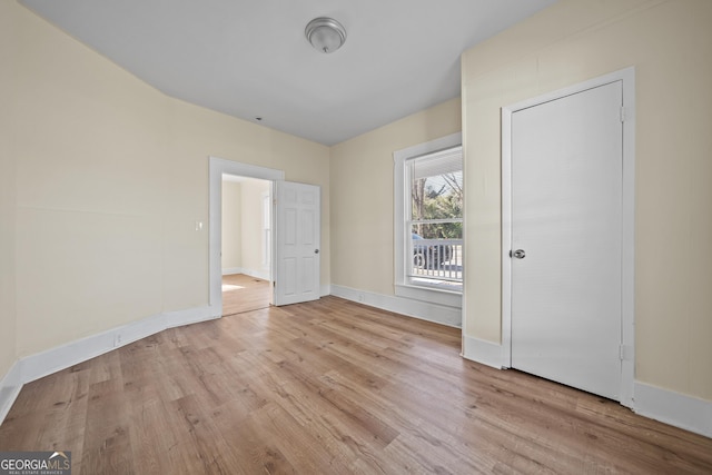 unfurnished bedroom with baseboards and light wood-type flooring