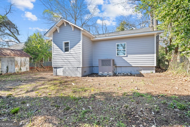 rear view of property with crawl space, central air condition unit, a shed, and an outdoor structure