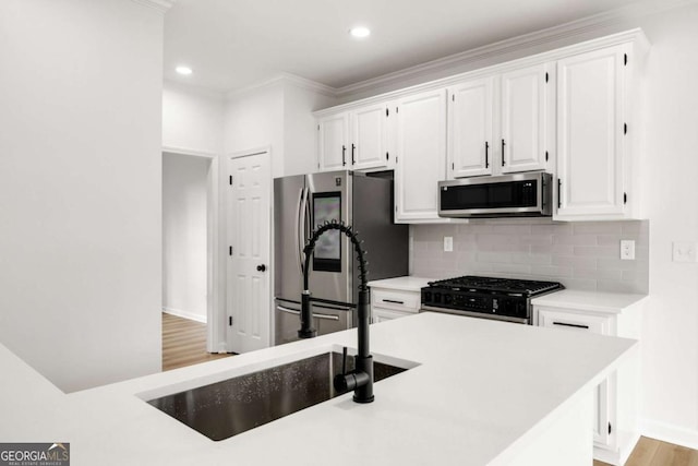 kitchen featuring backsplash, white cabinetry, stainless steel appliances, and light countertops