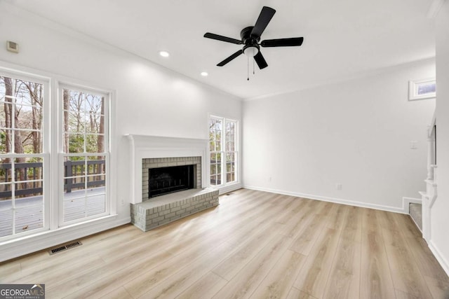 unfurnished living room with wood finished floors, visible vents, baseboards, recessed lighting, and a brick fireplace