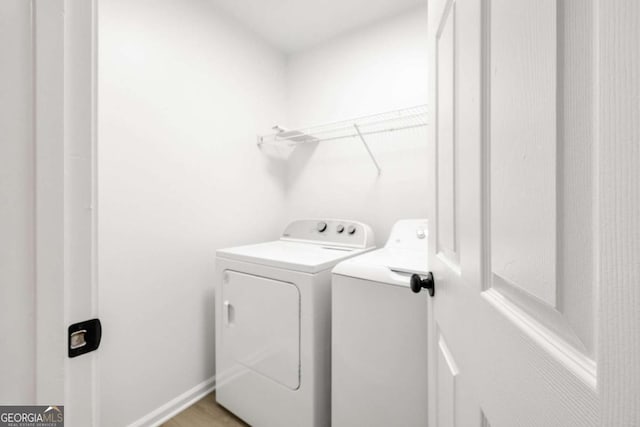 clothes washing area featuring laundry area, independent washer and dryer, and baseboards