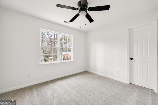 carpeted empty room featuring a ceiling fan and baseboards