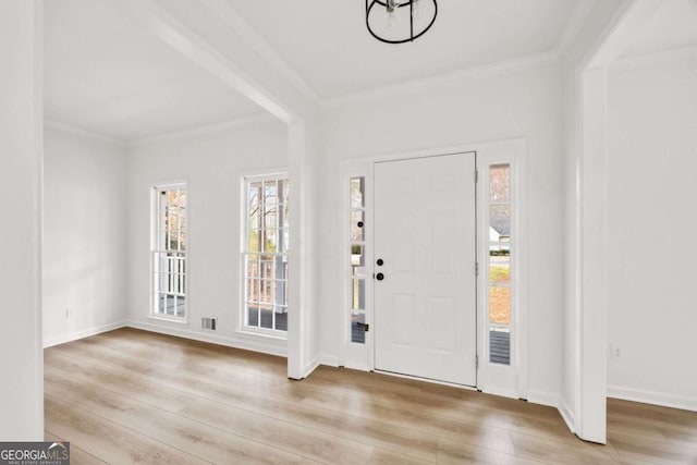 foyer with baseboards, wood finished floors, and crown molding