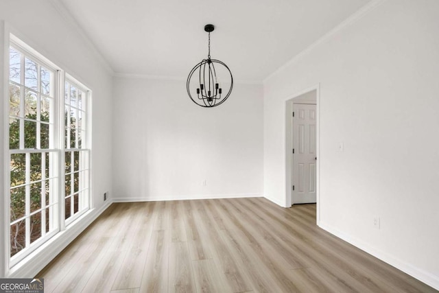 spare room with crown molding, a notable chandelier, baseboards, and light wood-type flooring