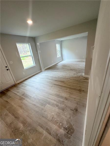 interior space with a wealth of natural light, baseboards, and wood finished floors