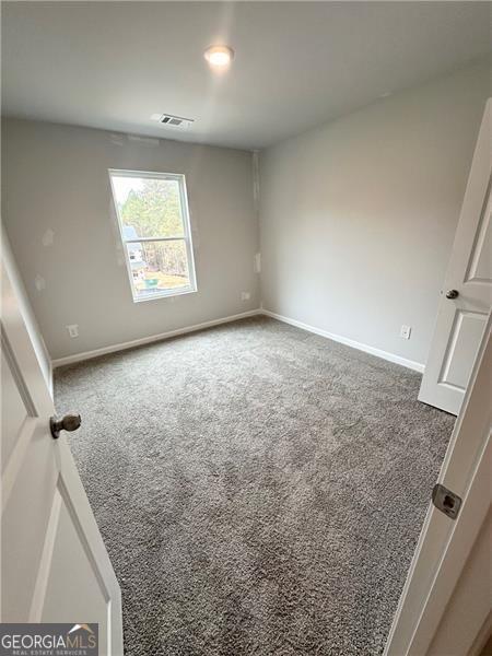 bedroom featuring carpet flooring, visible vents, and baseboards