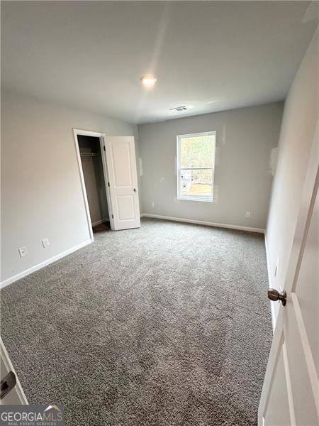 unfurnished bedroom featuring carpet and baseboards