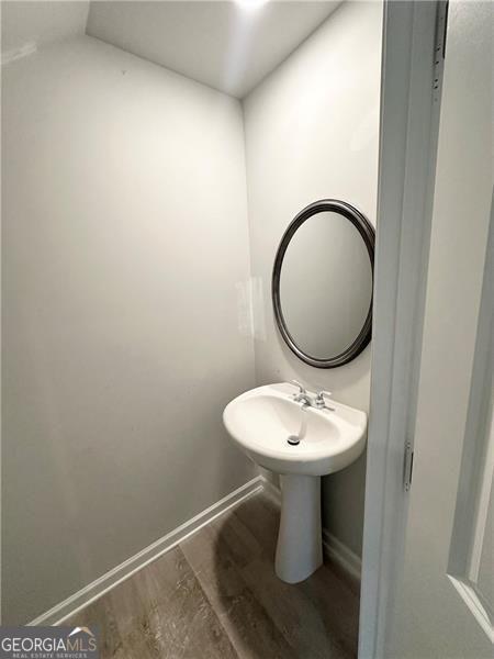 bathroom featuring a sink, baseboards, and wood finished floors