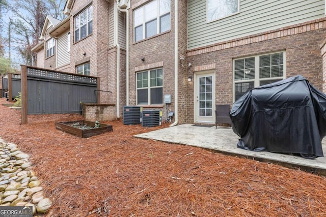 back of house with a patio, brick siding, and central AC