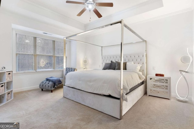 bedroom with baseboards, a tray ceiling, ceiling fan, ornamental molding, and carpet flooring