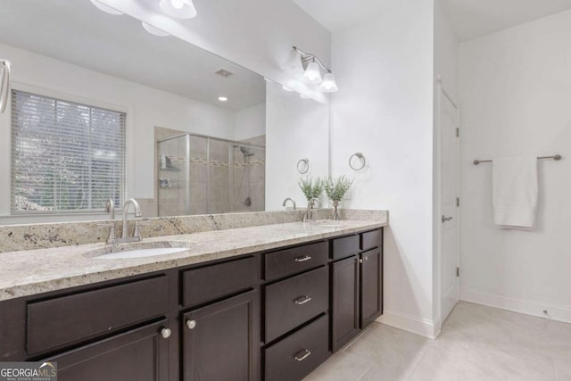 full bathroom featuring tile patterned flooring, a shower stall, double vanity, and a sink