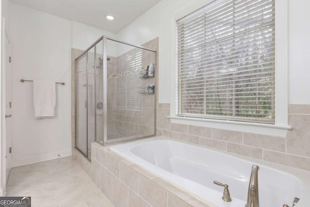 full bathroom with tile patterned floors, plenty of natural light, a shower stall, and a garden tub