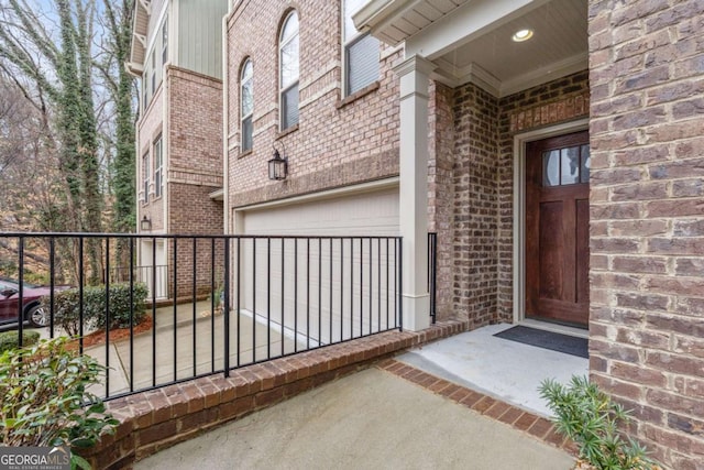 doorway to property with brick siding and an attached garage