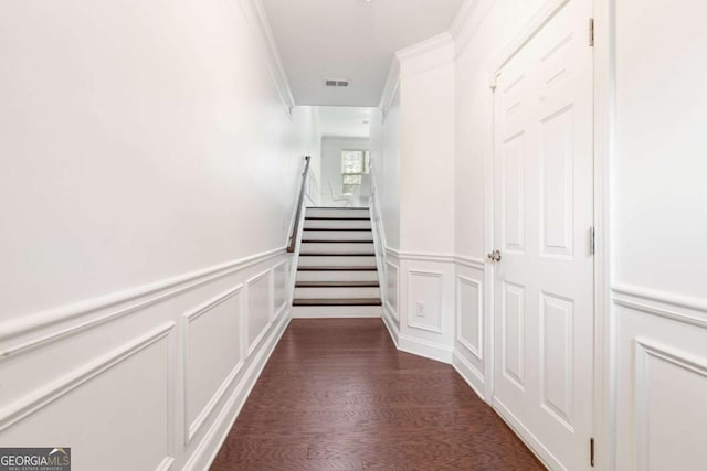 hall with visible vents, a wainscoted wall, dark wood-style flooring, and crown molding