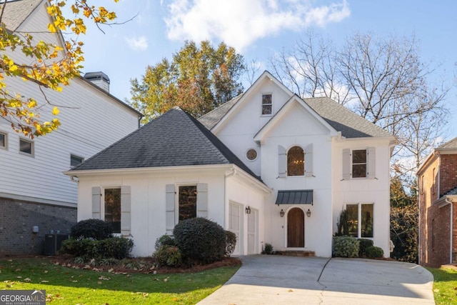 view of front of home with driveway, an attached garage, a shingled roof, a front lawn, and central air condition unit