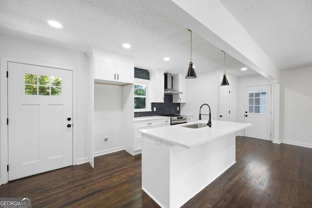 kitchen with a sink, wall chimney exhaust hood, dark wood-style flooring, and stainless steel range with electric cooktop